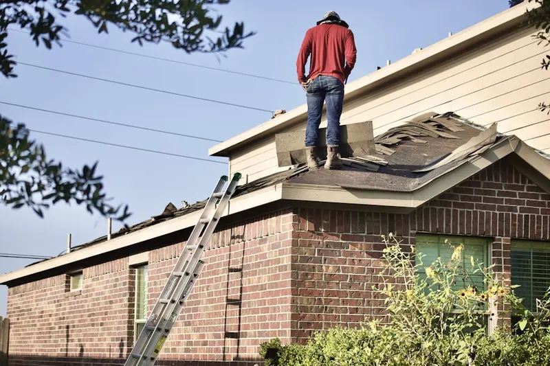 Professional roofer working on a residential roof in East Pepperell